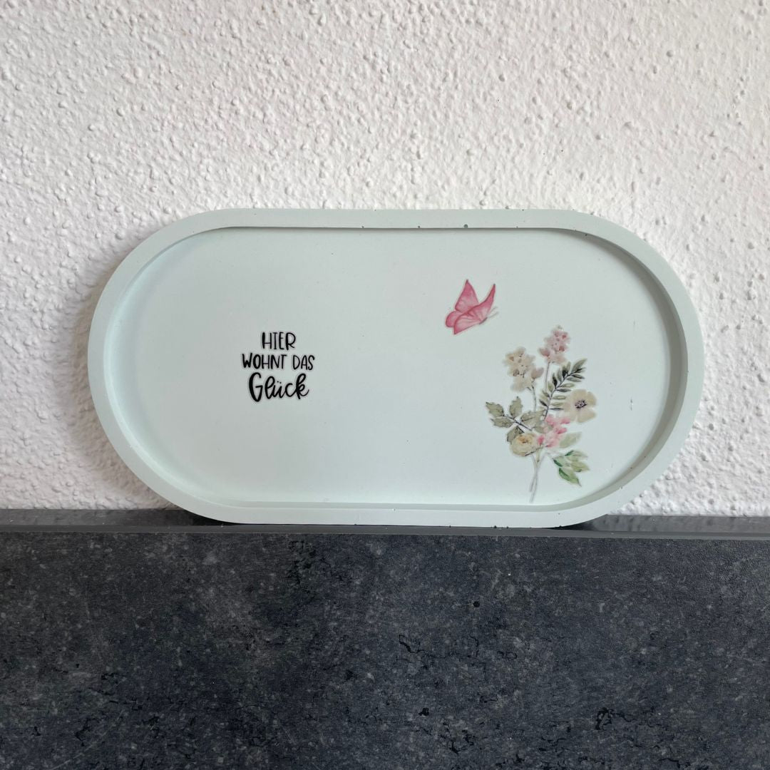 Ovale Platte in Minzgrün mit Sticker "Hier wohnt das Glück", Blume und Schmetterling